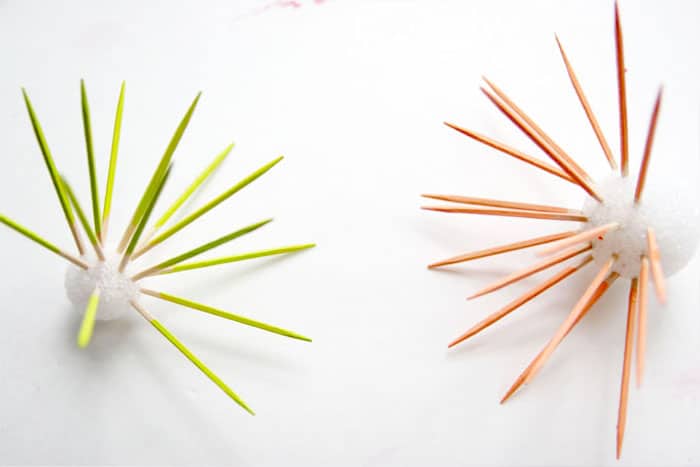 Painting toothpicks with lime green and peach acrylic paint