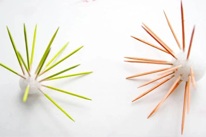 Painting toothpicks with lime green and peach acrylic paint