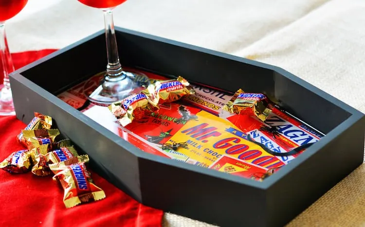 Turn a plain wood coffin decoration into a DIY Halloween tray covered with creepy crawlies! Perfect for surprising guests when they grab a piece of candy.