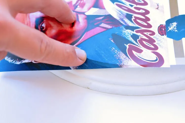 Making a crease with the paper design on the edge of a plaque using a finger