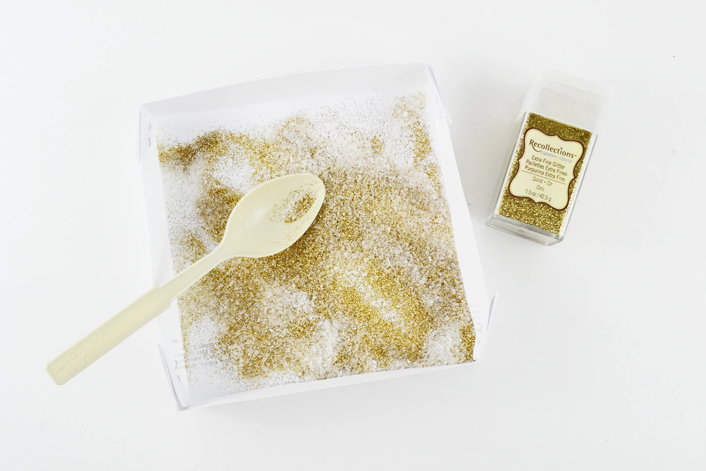 Gold glitter in a tray with a spoon