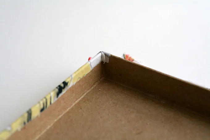 Fold the fabric edges over the box