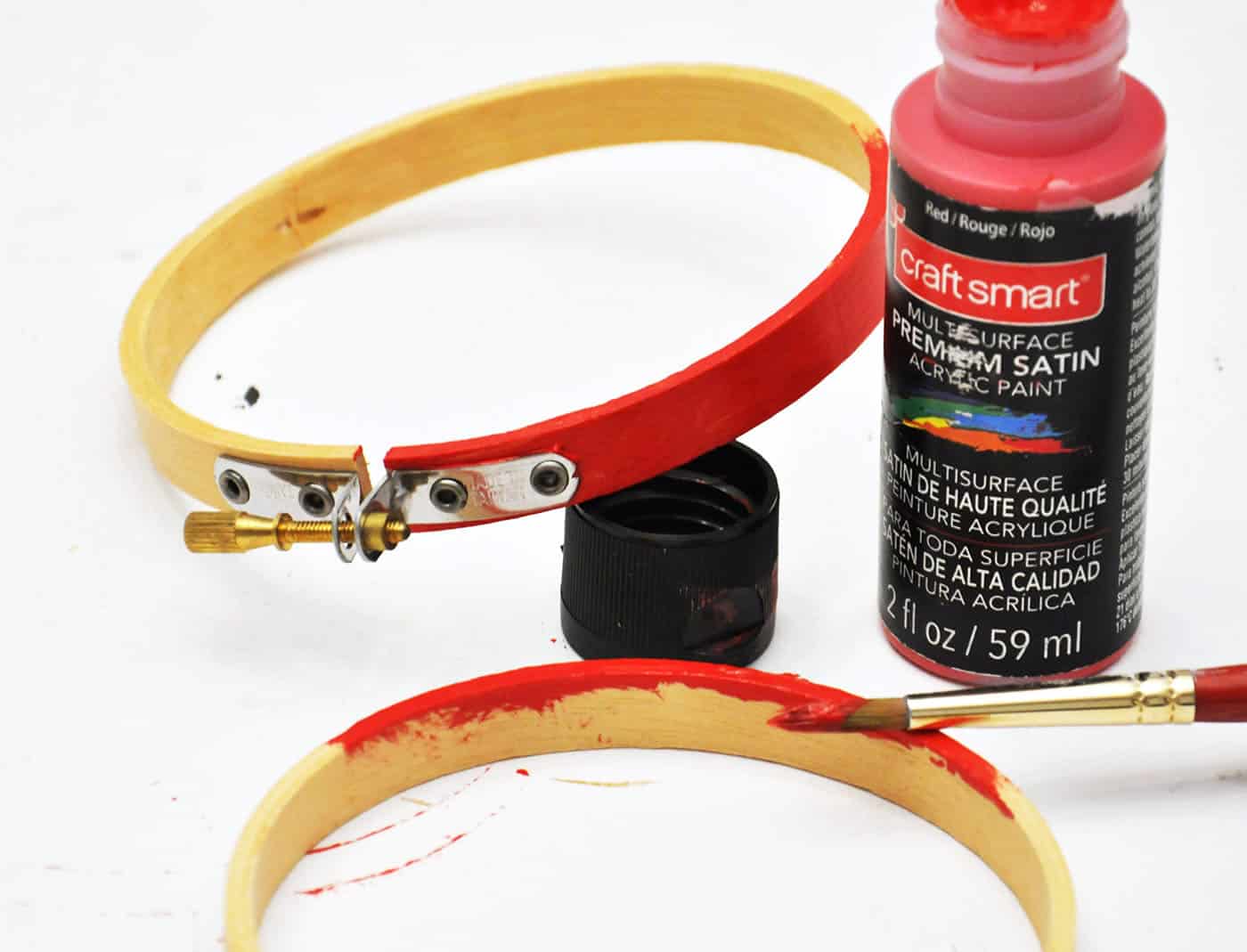 Painting an embroidery hoop with red paint