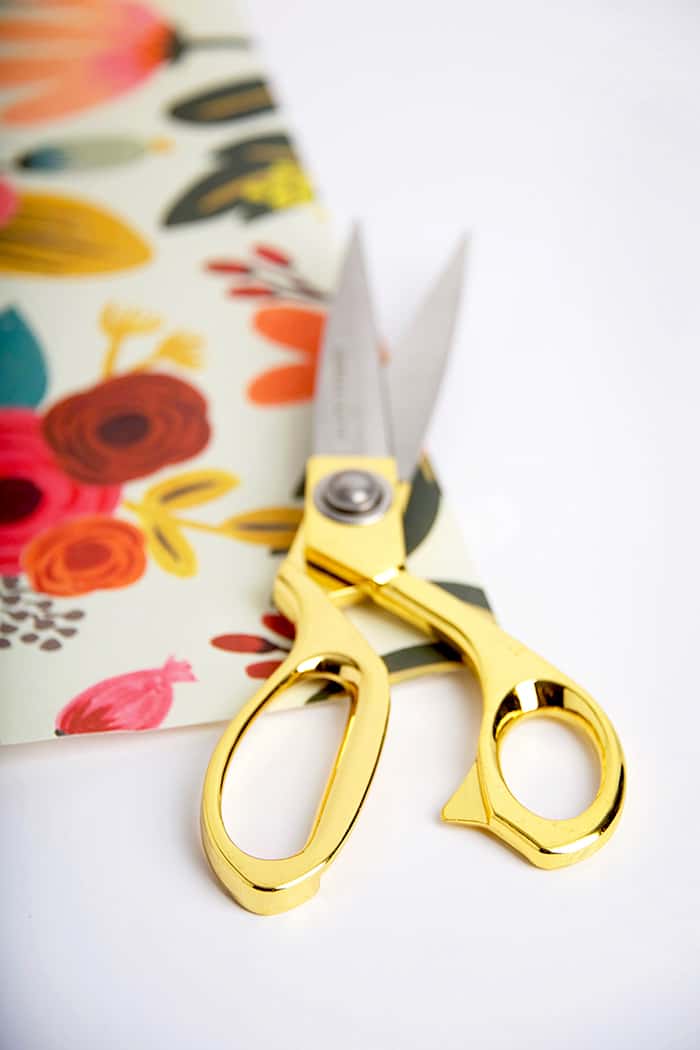 Cutting out paper with gold handled scissors