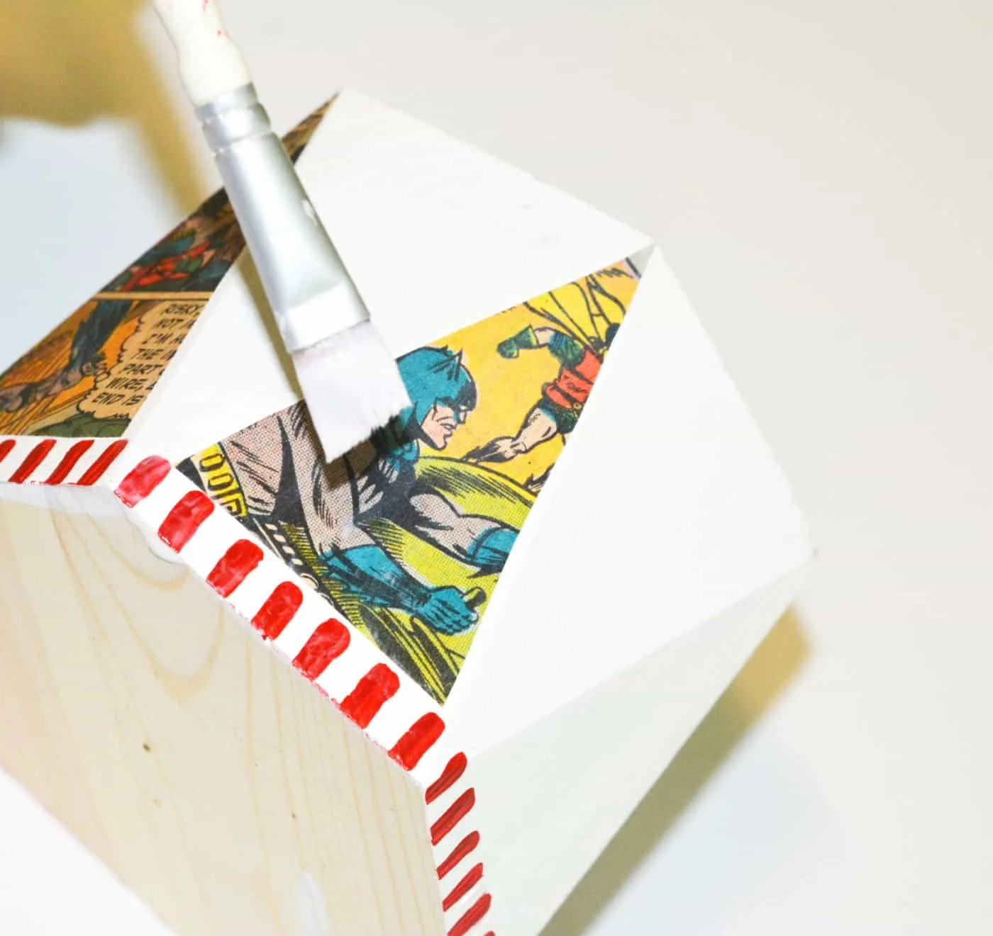 Add the comic book cut outs to the side of the pencil cup with Mod Podge