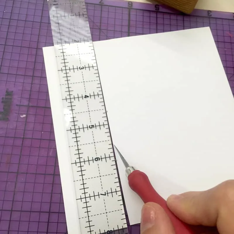 Cutting scrapbook paper with a ruler and craft knife