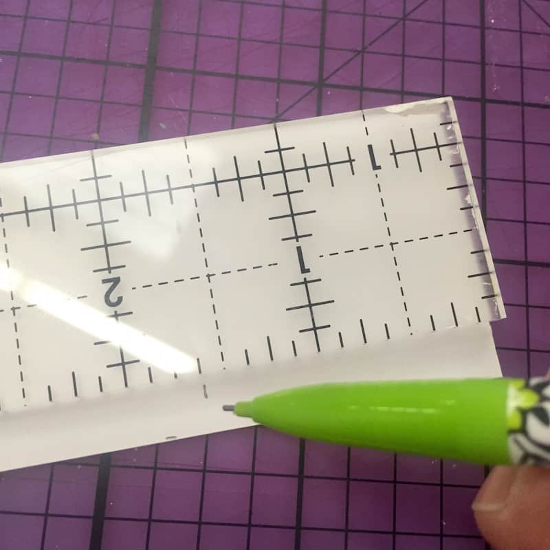 Measuring and marking the back of scrapbook paper with a pencil