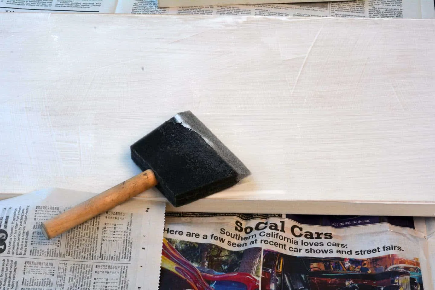 Apply Mod Podge to a board with a foam brush