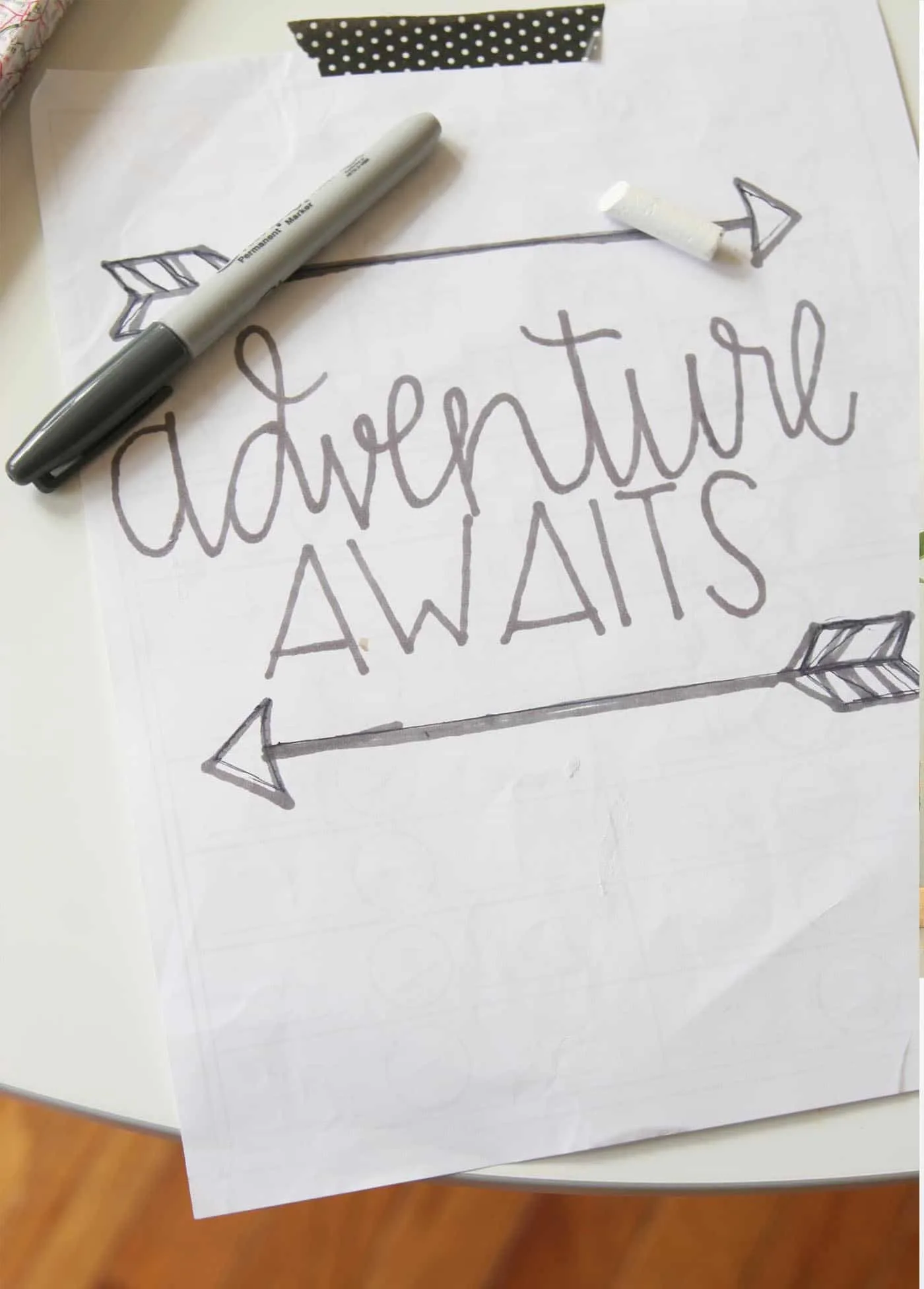 Adventure awaits written on paper with a Sharpie