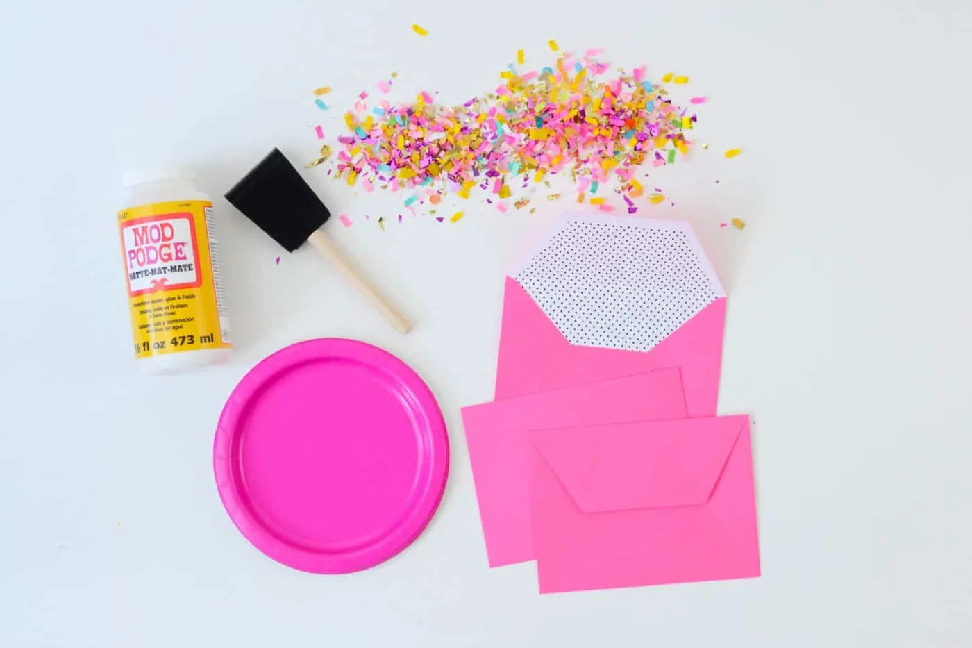 Mod Podge Matte, pink plate, envelopes, confetti, and a foam brush