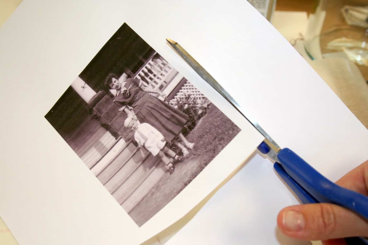 Cutting out a vintage image with blue handled scissors