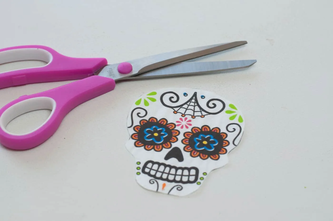 Calaveras skull design cut out of napkins and pair of scissors 