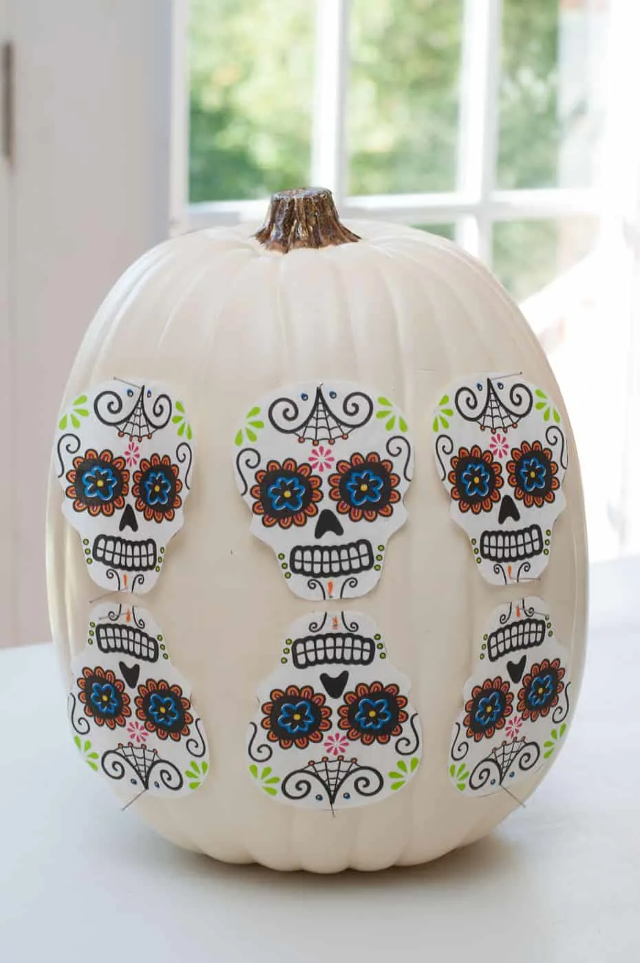 Sugar skull napkin shapes pinned onto the side of the pumpkin
