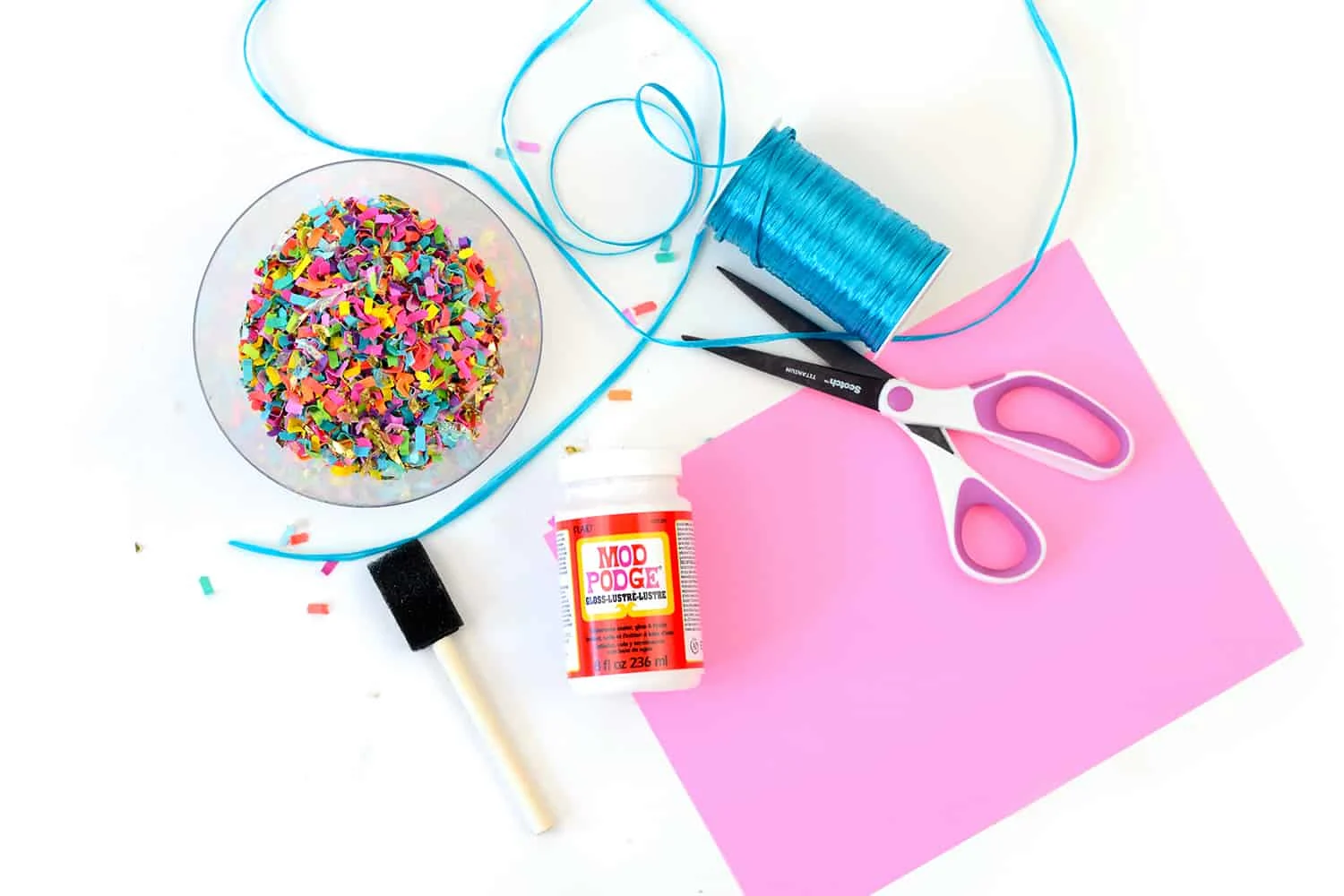 Confetti, ribbon, scissors, Mod Podge, pink cardstock, and a foam brush