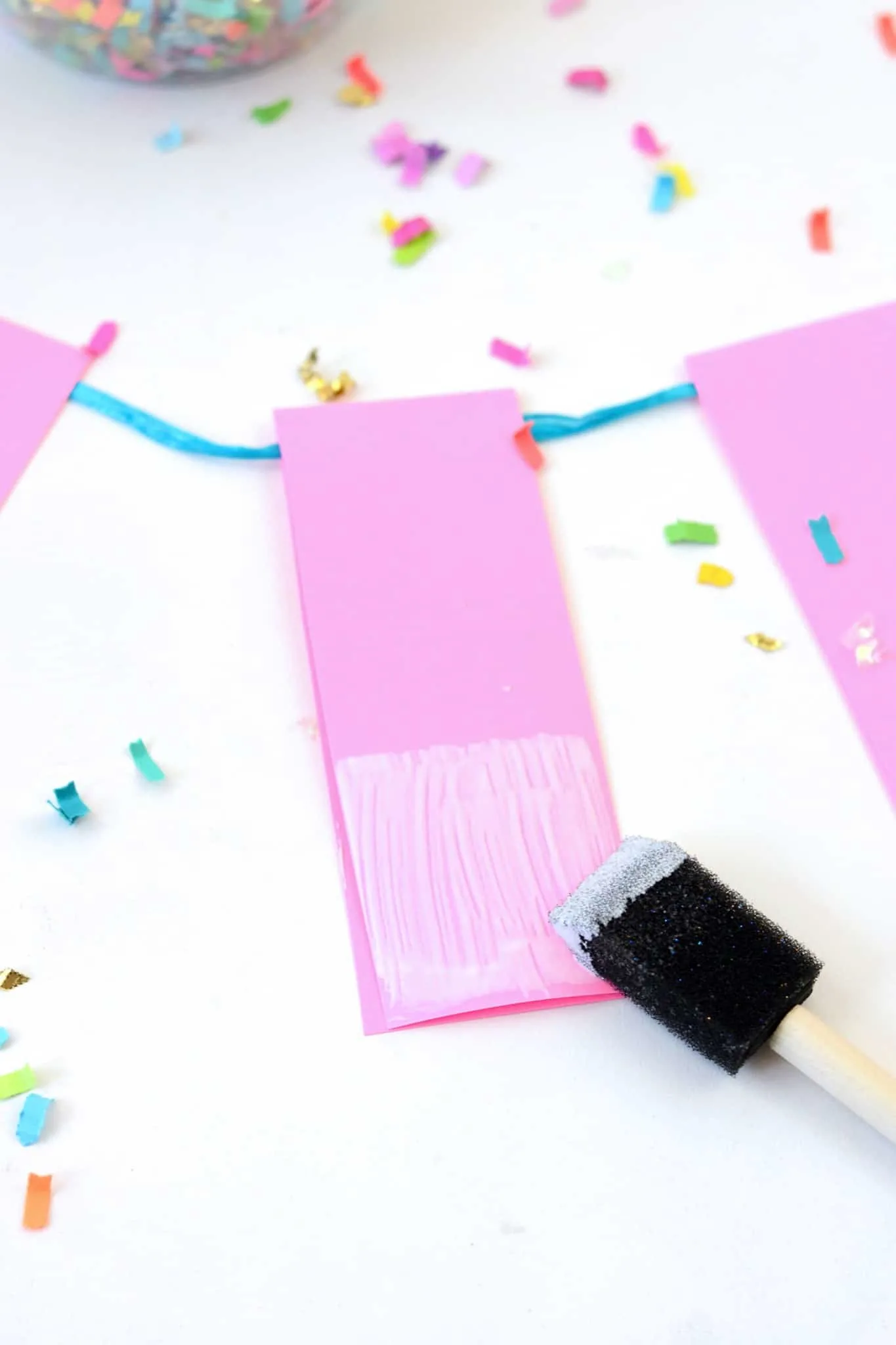 Adding Mod Podge to the bottom of the paper strips with a foam brush