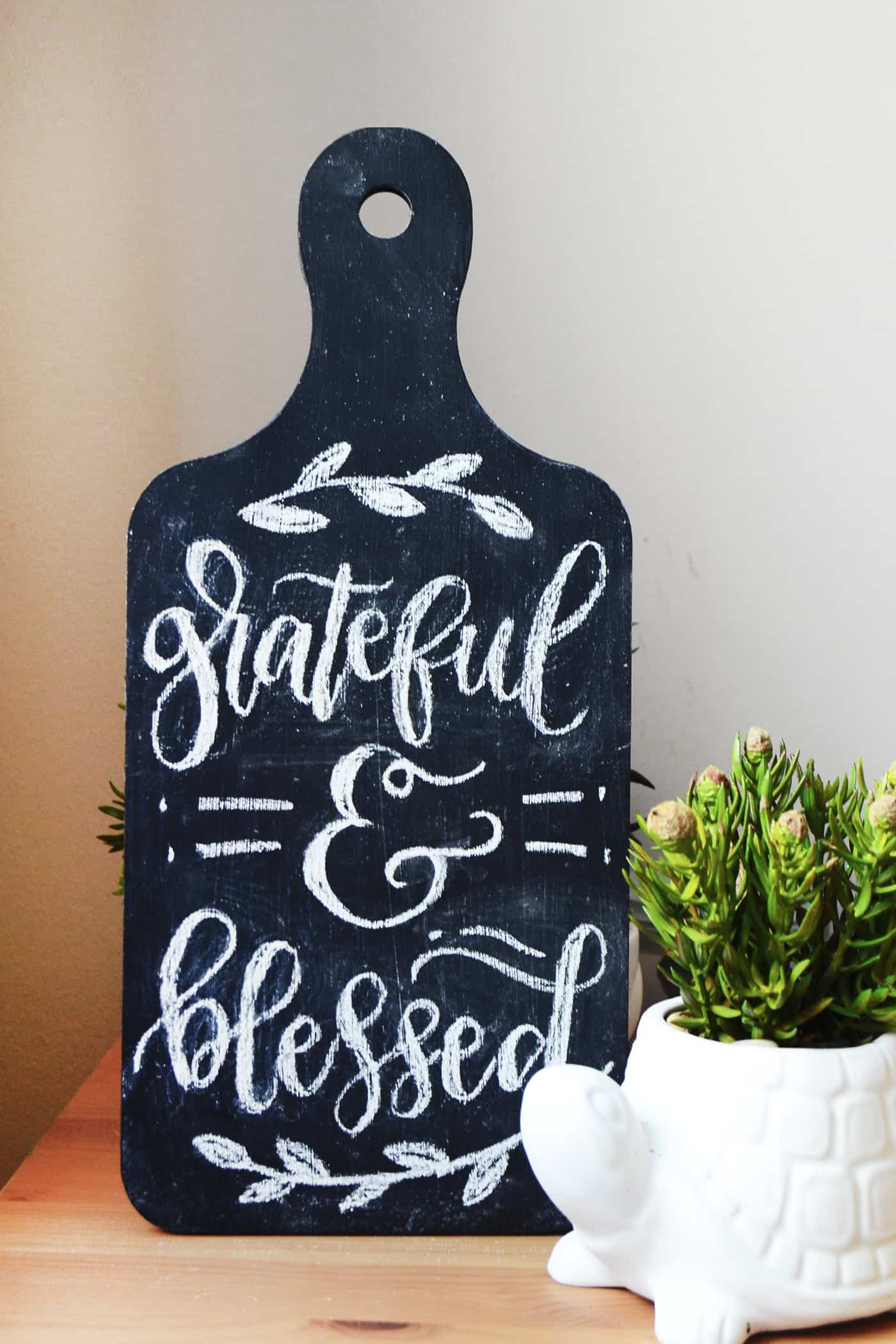 Bread board painted with black chalkboard paint displayed for the holidays
