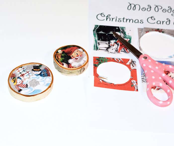 Christmas images cut out to fit wood slices with a pair of scissors