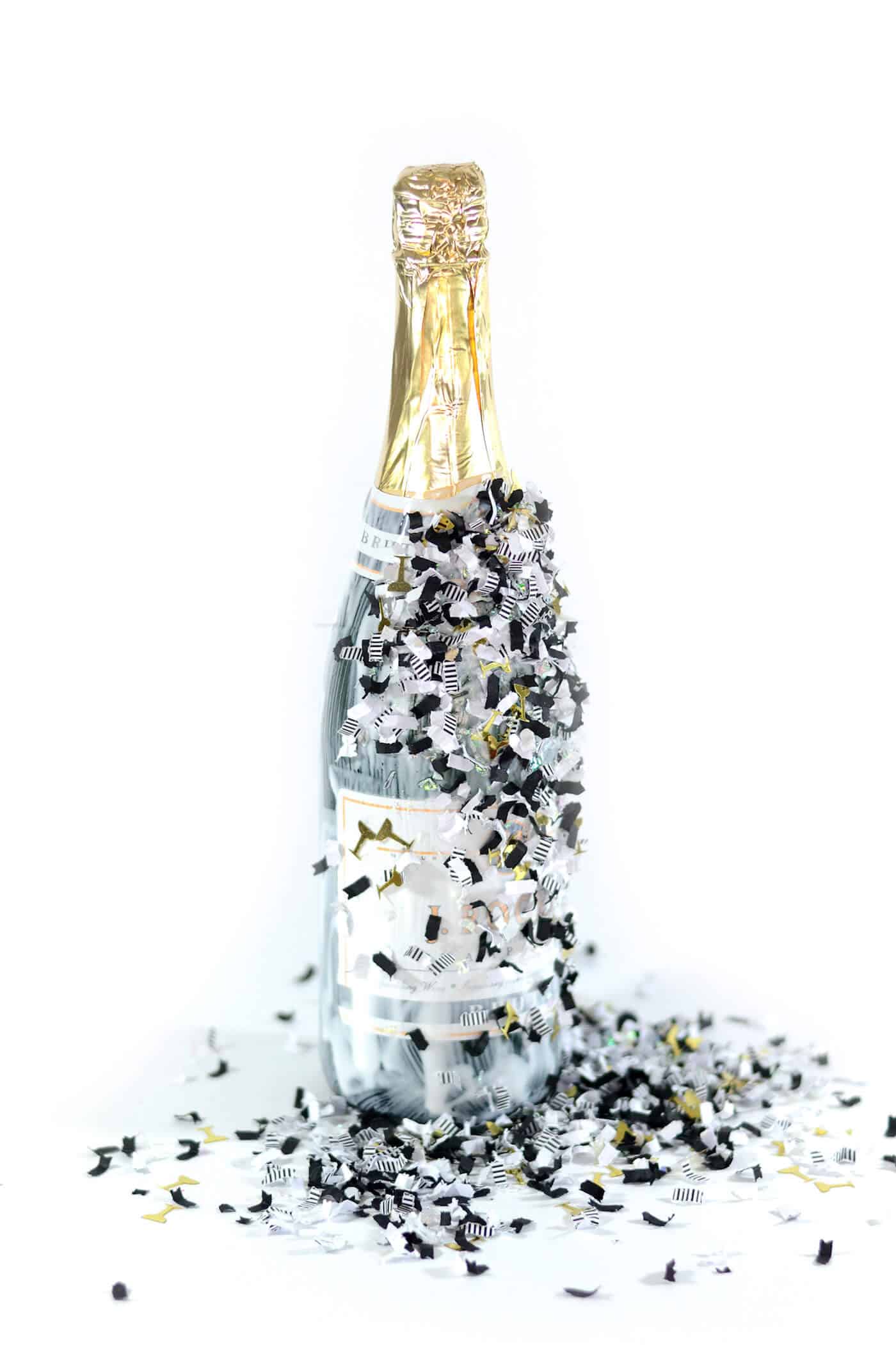 Confetti sprinkled over a bottle covered in Mod Podge
