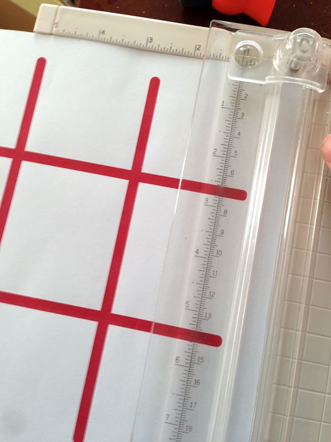 Trimming a tic tac toe game template with a paper cutter