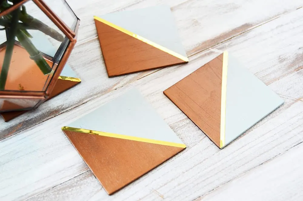 These trendy copper and gold DIY coasters are so easy to make using wood squares! Perfect for entertaining or giving as gifts.