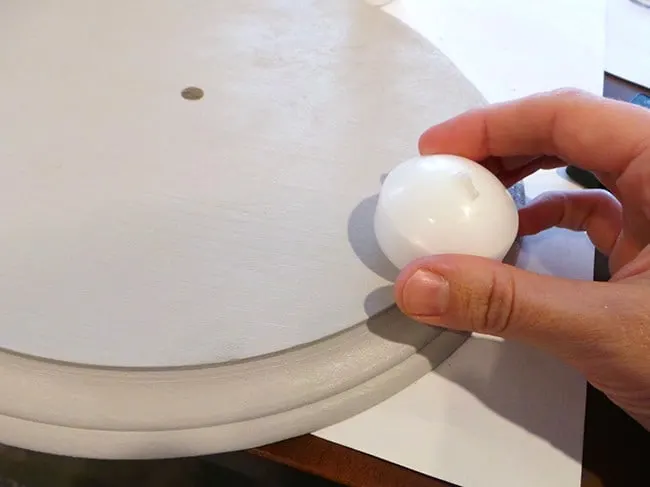 Rubbing a clock surface with a white candle