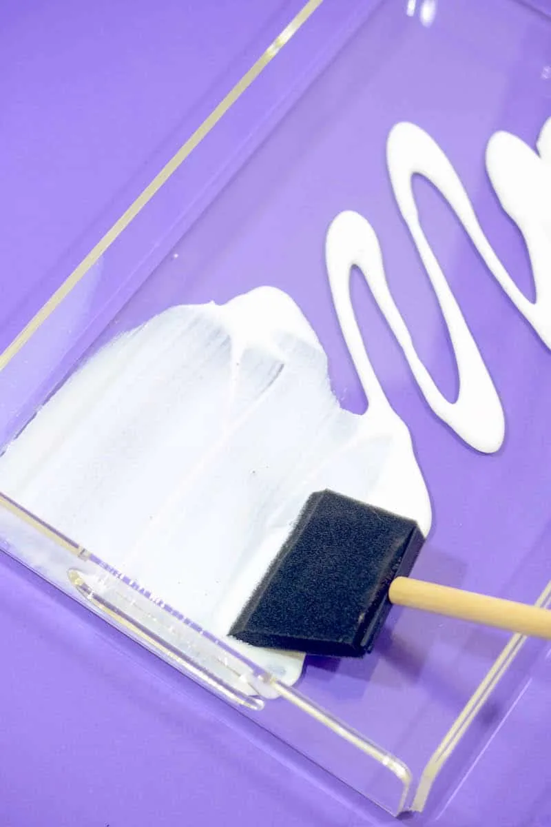 Spreading Mod Podge inside the tray with a foam brush
