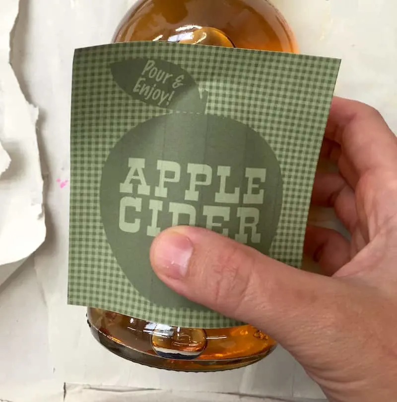 Placing an apple cider label on a bottle