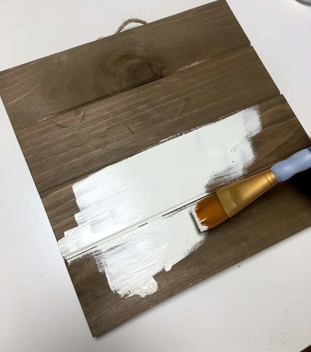 Painting a brown wood pallet with white paint