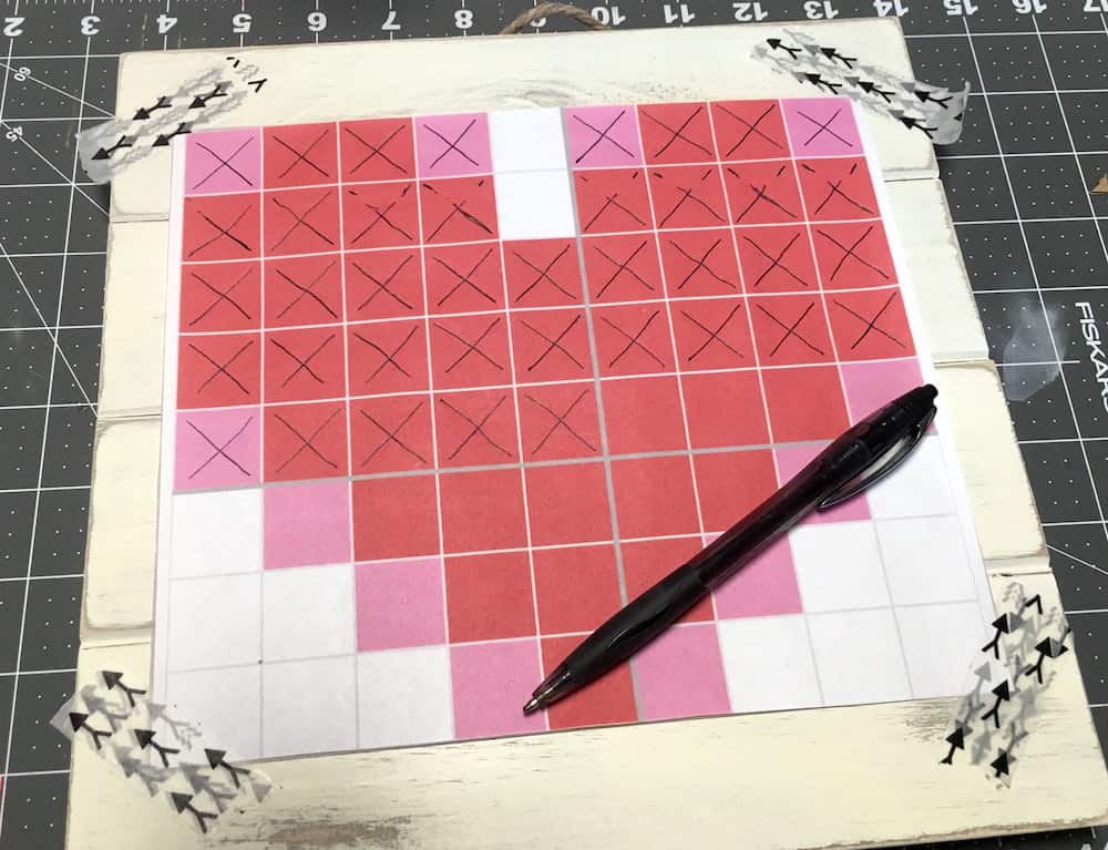 Making Xs with a pen on the pattern