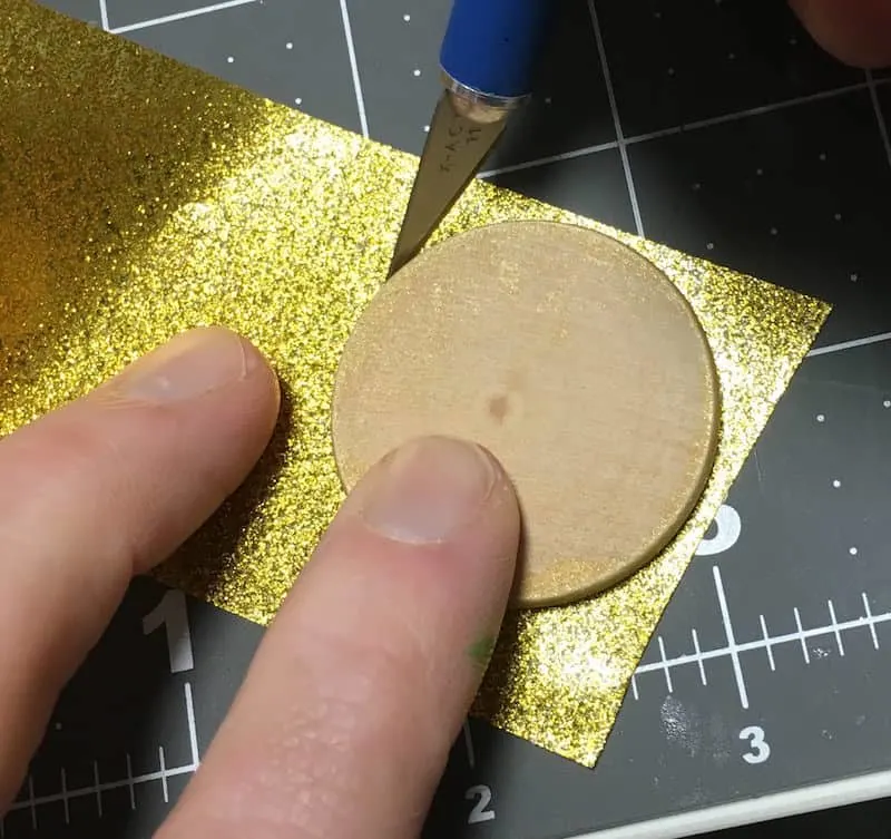 Tracing a wood circle on gold glitter Duck Tape