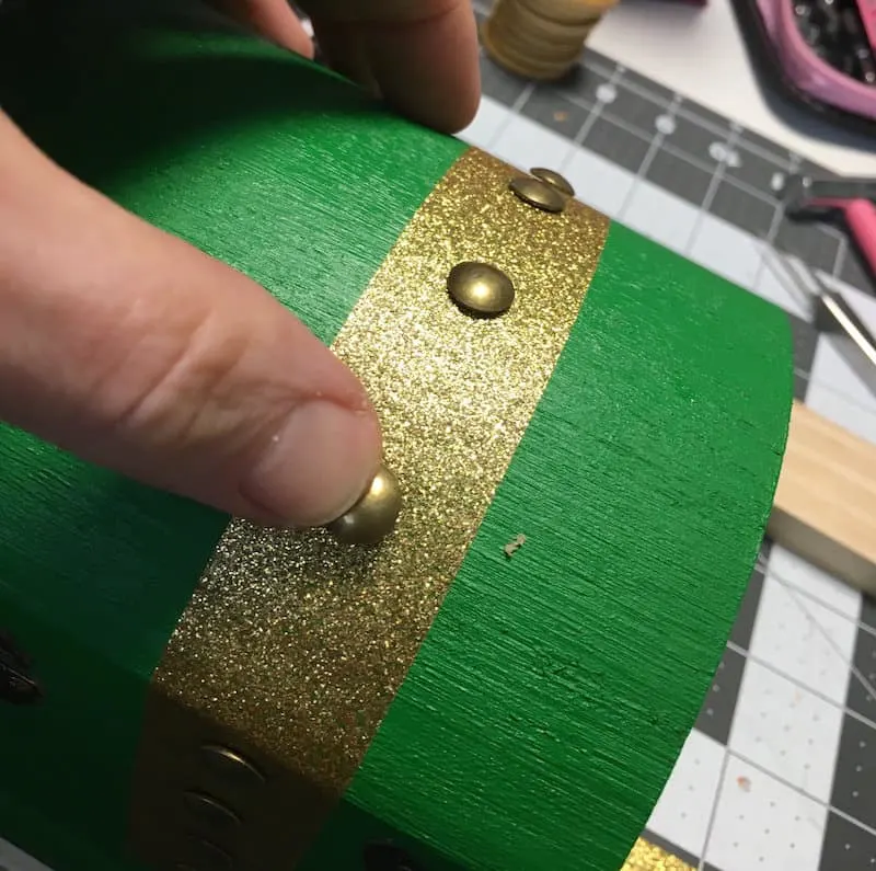 Place gold brads into a green painted wooden chest