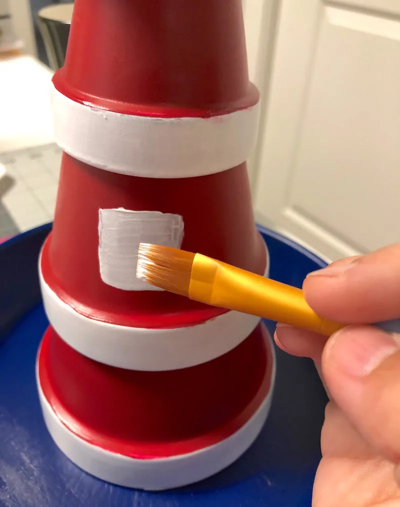 Paint the windows onto the clay pot lighthouse