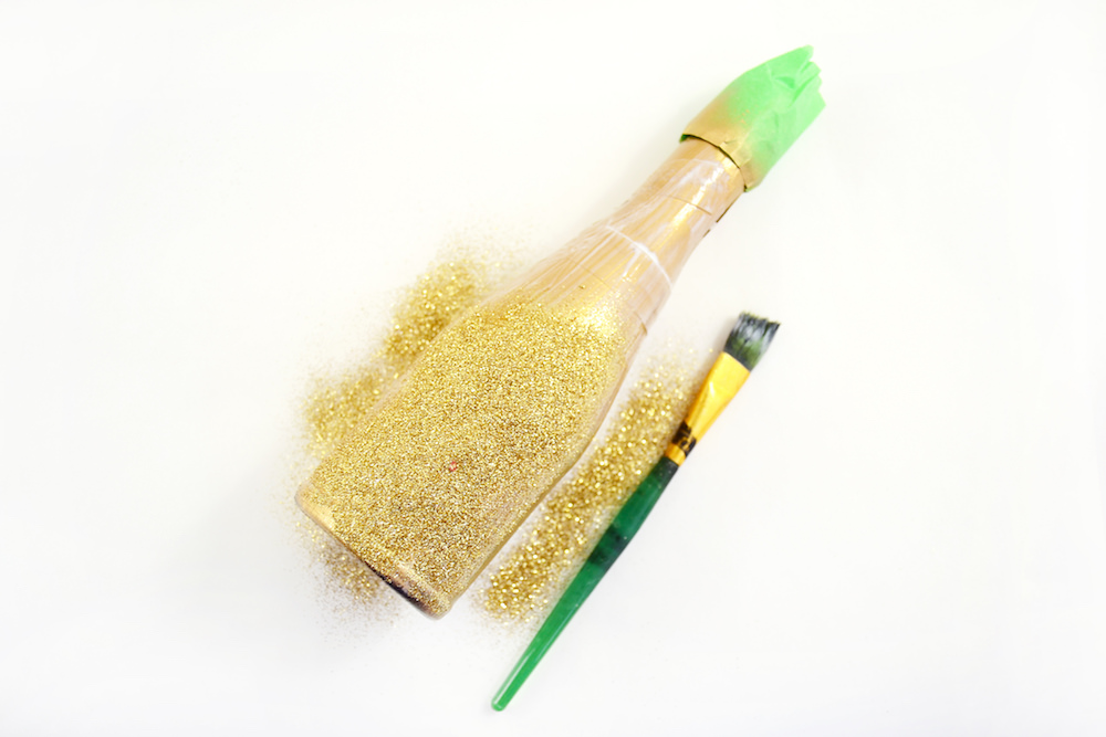 Apply a layer of Mod Podge to the bottle and sprinkle glitter