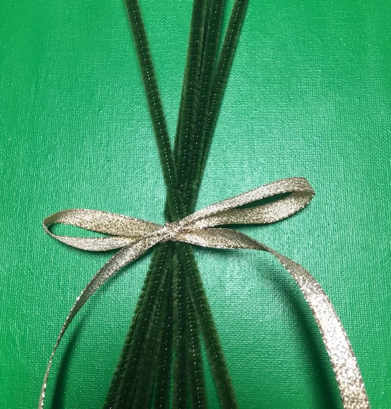 Gold ribbon tied around green pipe cleaners