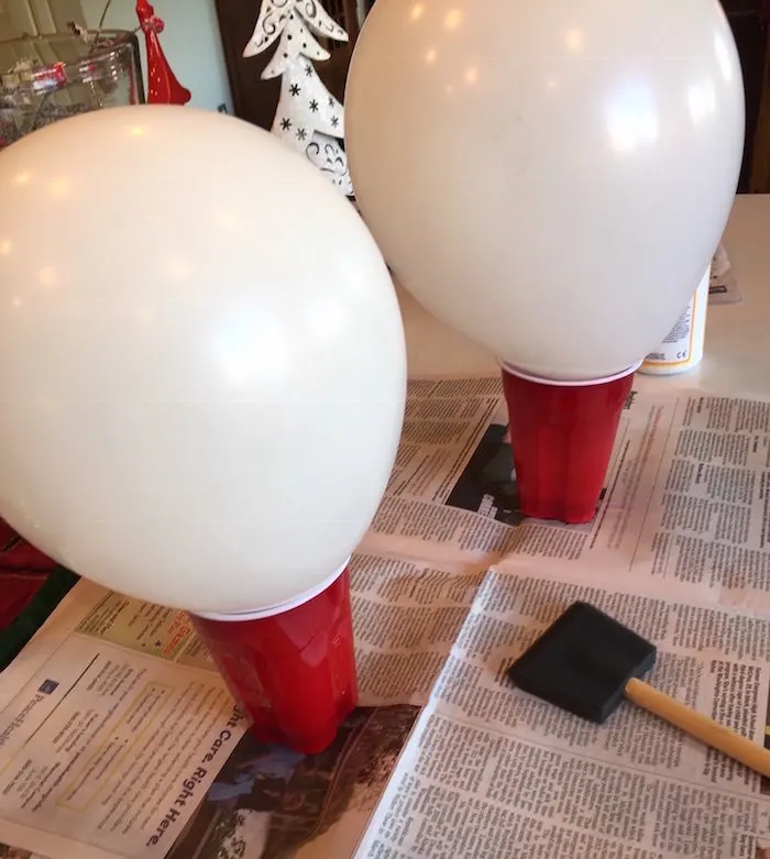 Two blown up balloons sitting in red Solo cups