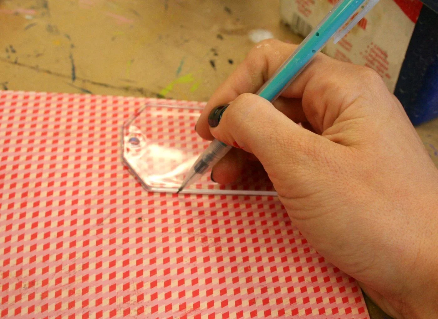 Tracing a gift tag shape onto scrapbook paper with a pencil