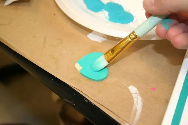 Painting a wooden heart with turquoise craft paint