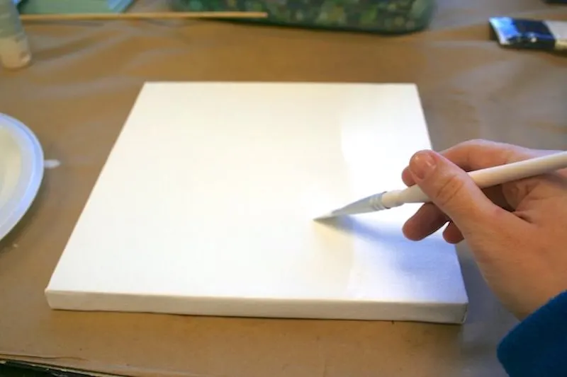 Priming a canvas with white paint