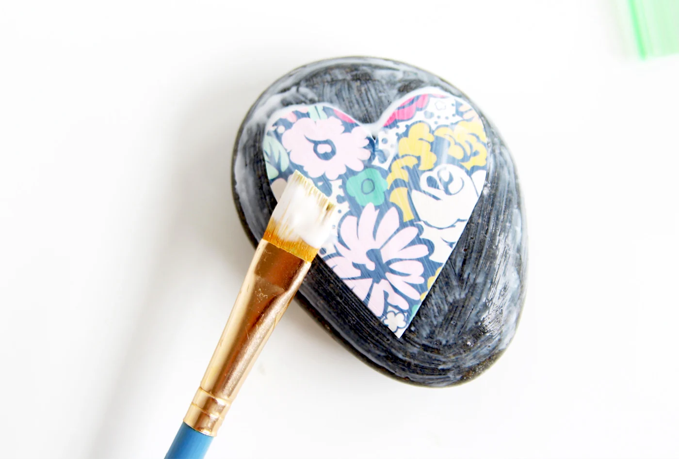 Applying the paper heart shape to the rock and brushing over the top with Mod Podge