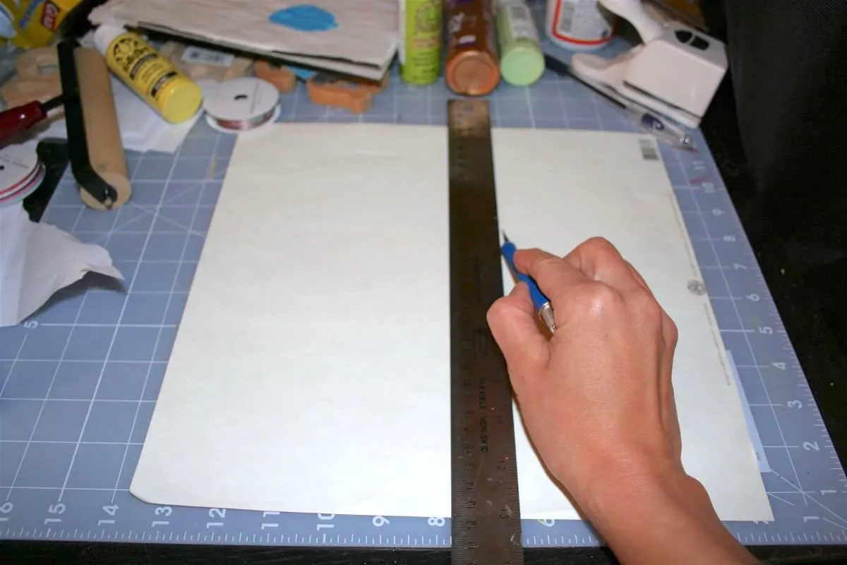 Cutting paper to fit the tray with a ruler and craft knife