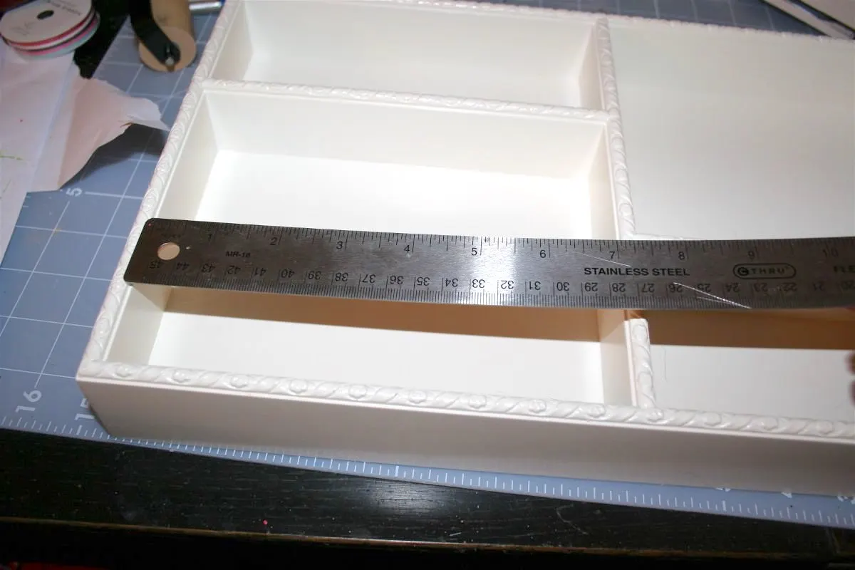 Measuring the compartments of the tray with a ruler