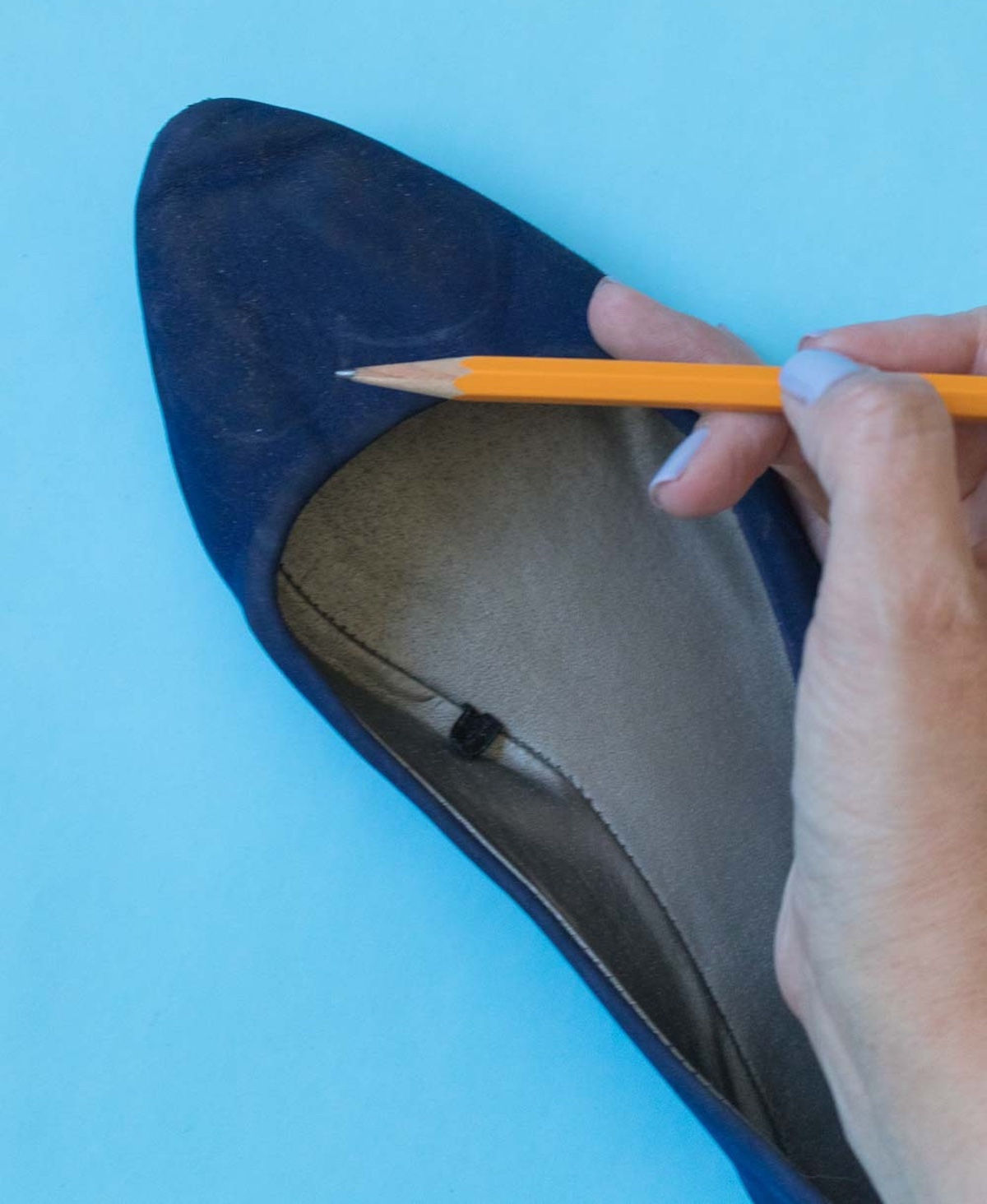 Drawing a heart at the end of a blue shoe with a pencil