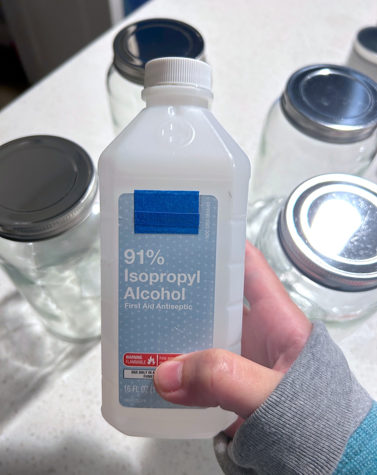 hand holding a bottle of rubbing alcohol