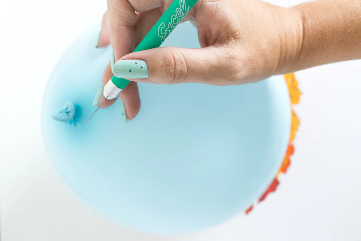 Deflating a balloon with a craft knife