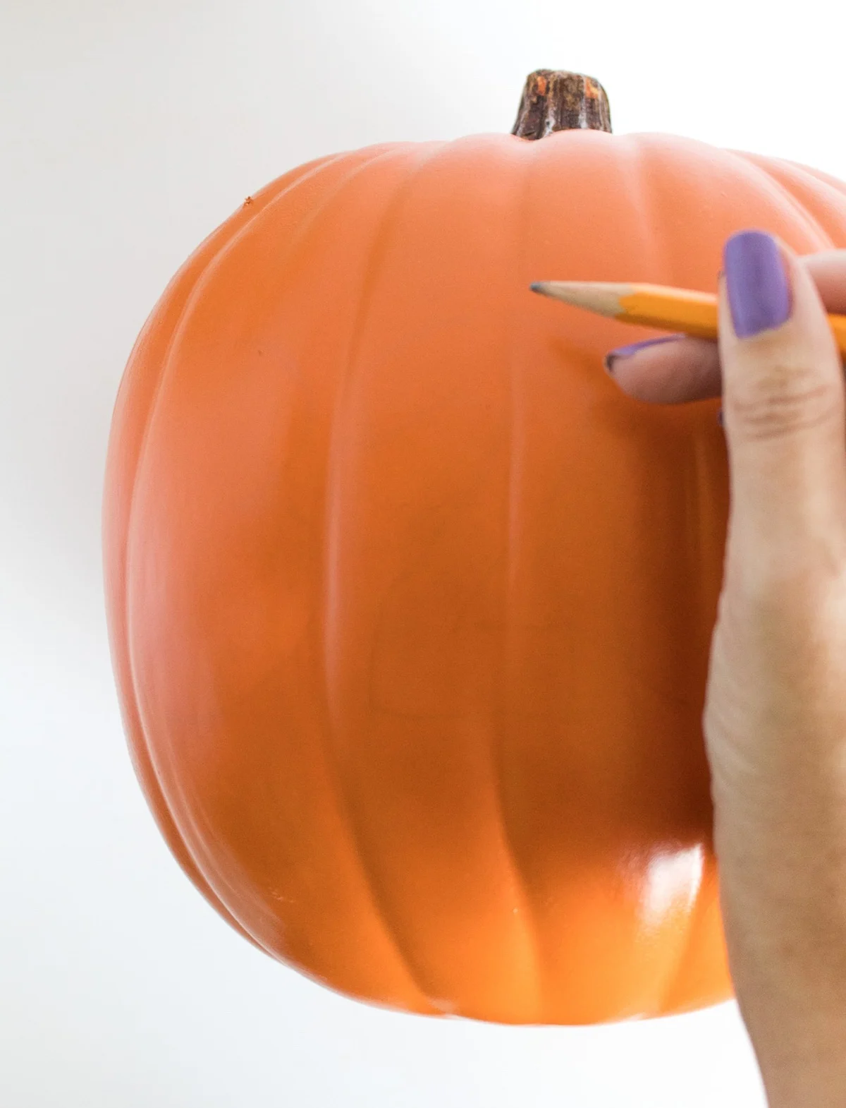 drawing the house number on the pumpkin with a pencil