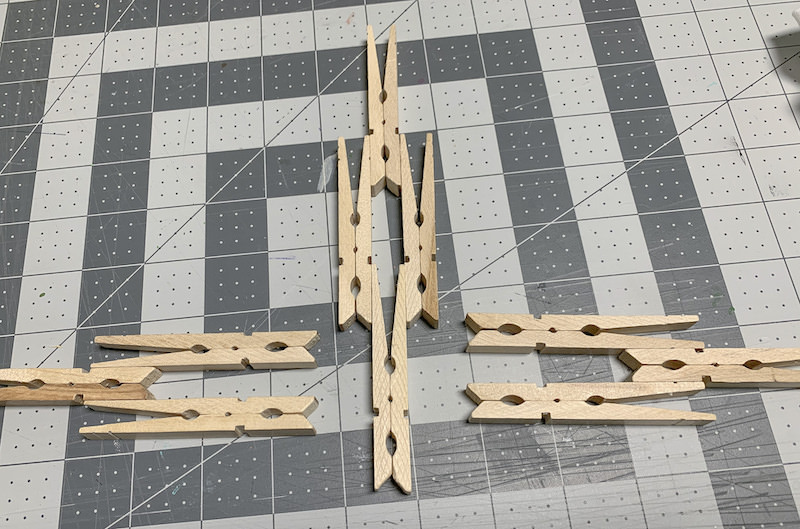 Clothespins-laid-out-on-a-cutting-mat-to-form-a-cross