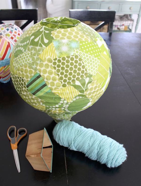 Paper lantern covered in fabric with a basket and skein of yarn