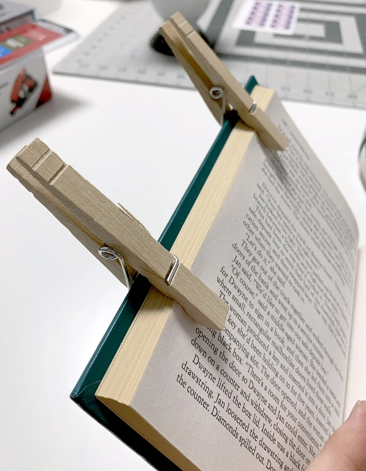 Clip the book open with clothespins