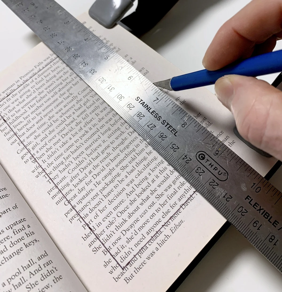 Using a craft knife to cut into the book pages