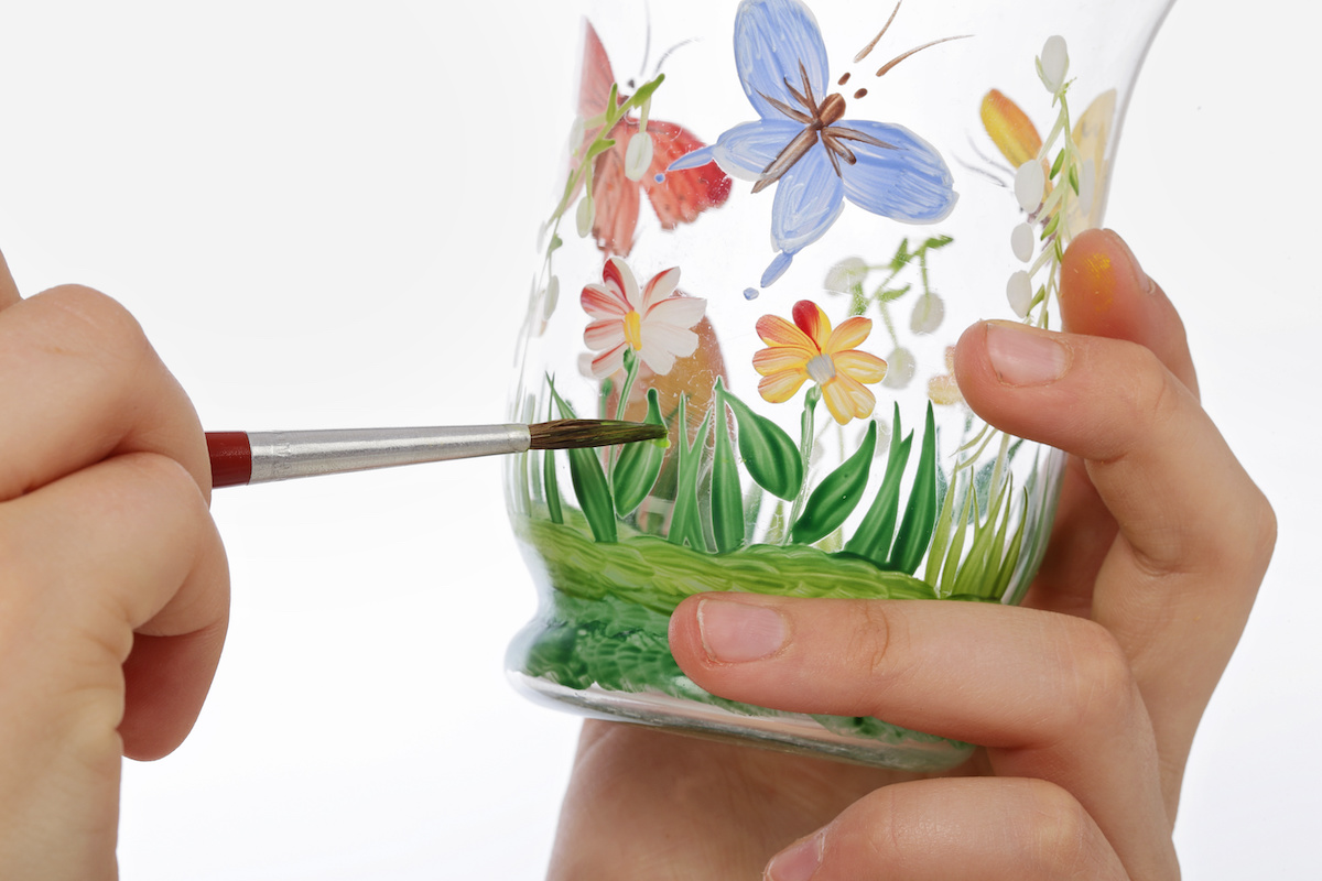 Painting-grass-and-butterflies-on-glass-with-a-paintbrush
